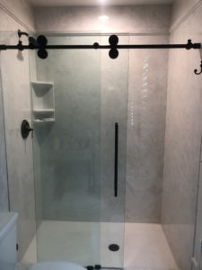 Cultured Marble Shower and Bypass Glass Enclosure with a Running Rail and Rollers
